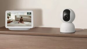 Câmera de segurança residencial Xiaomi Smart Camera C401 branca posicionada sobre uma superfície em ambiente interno